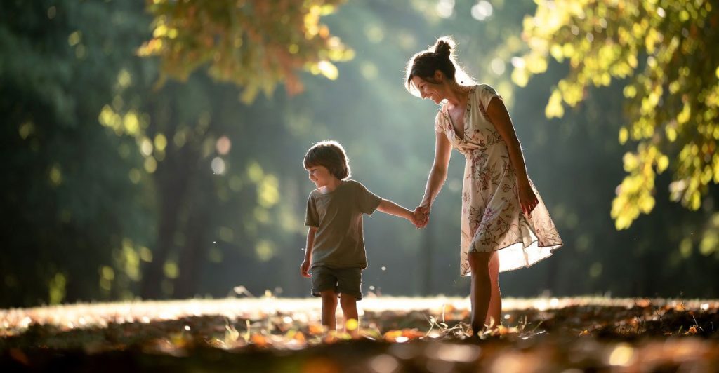 Genitore single con bambino che camminano insieme al parco