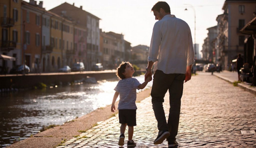 Genitore single con bambino lungo i Navigli a Milano